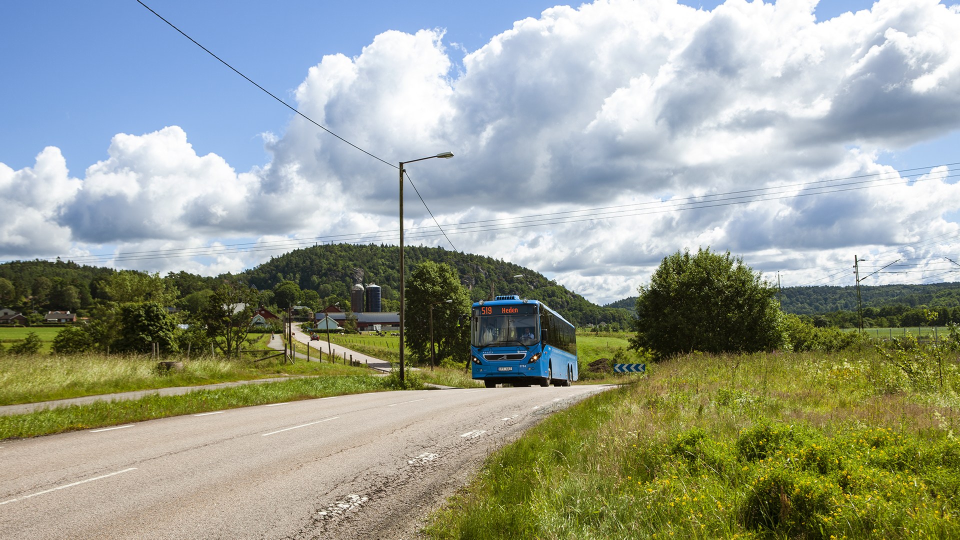 Bild som visar en blå buss som kör på en väg. 