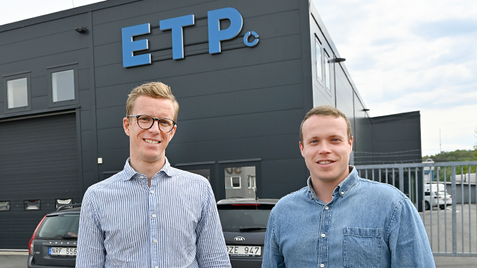 Bild på två personer framför kontorsbyggnad.