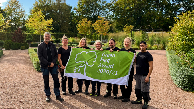 Bild på Jonsereds Trädgårdars personal när de håller i Green Flag Awards-flaggan.