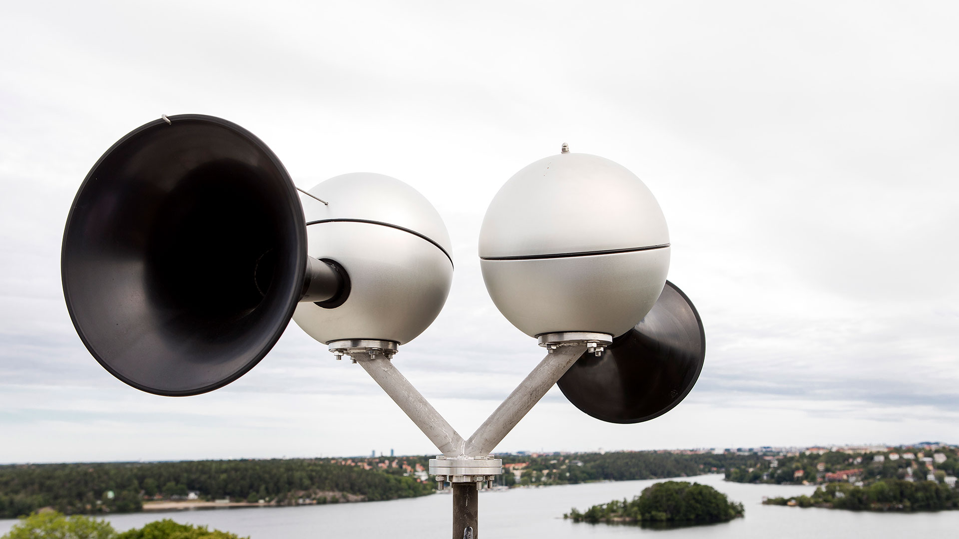 Bild på  utomhussändare som används för utomhuslarm med ljudsignal. Sändarna är monterade högt upp över bebyggelse.