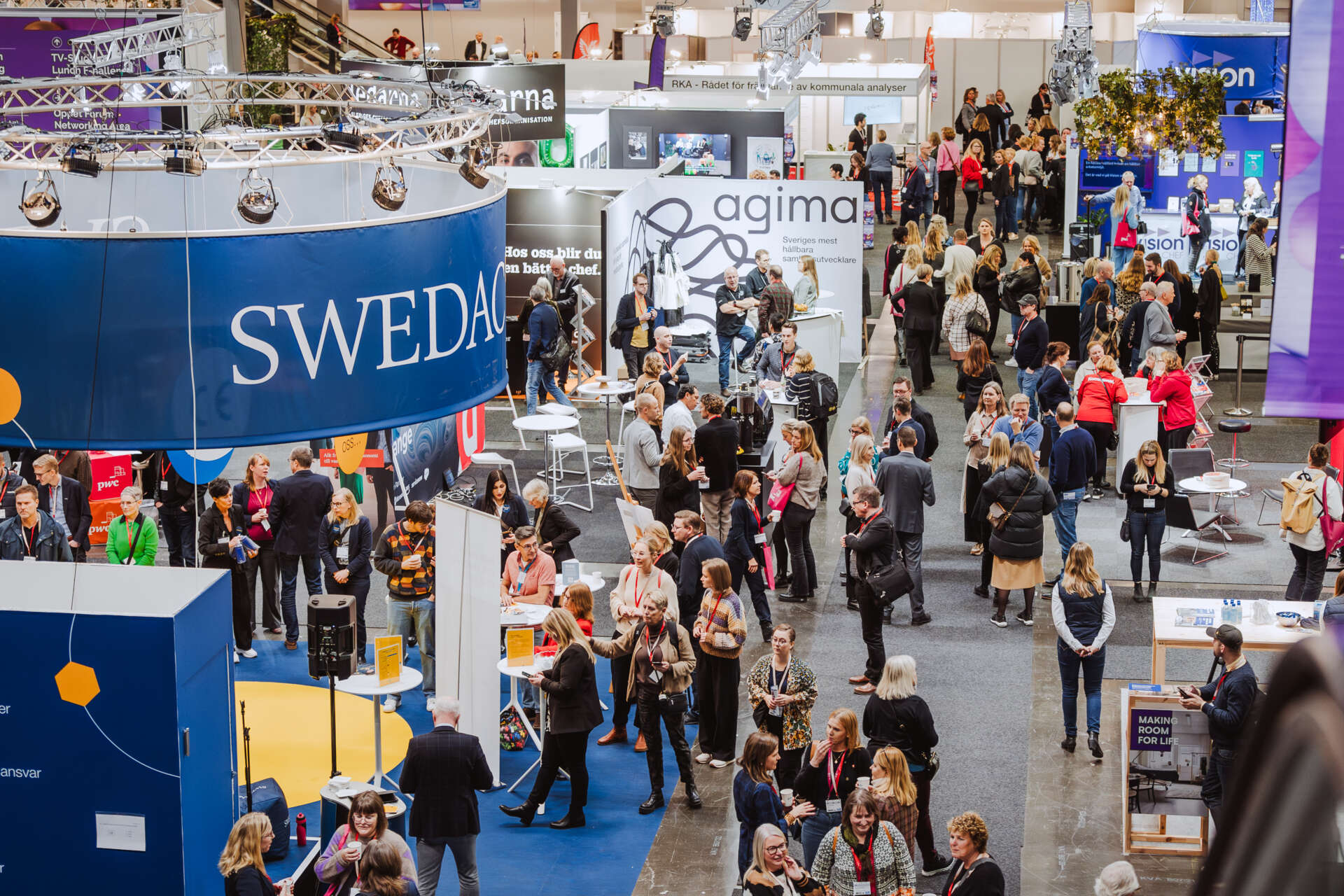 Utsikt över mässgolvet på Svenska Mässan. På mässgolvet finns besökare och montrar.