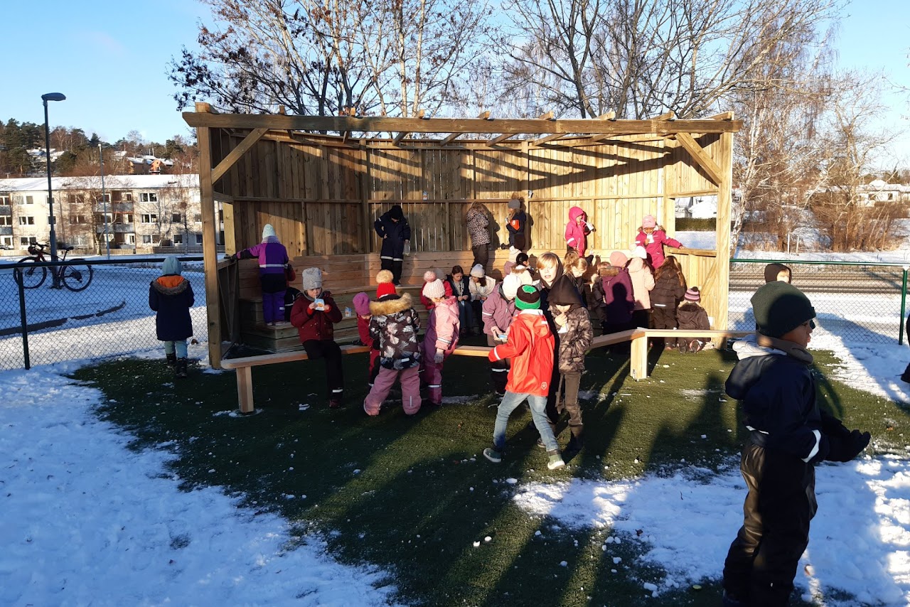 Bilden visar flera barn på en nybyggd läktare på en skolgård.