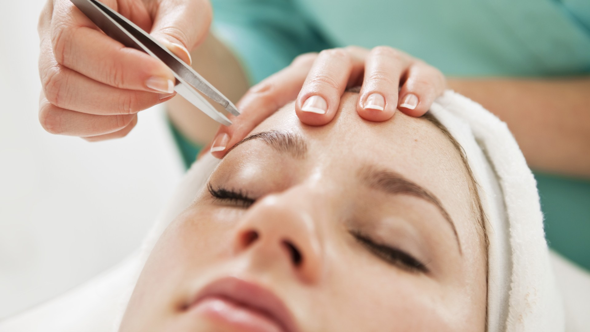 Kvinna får sitt ögonbryn skulpterat.