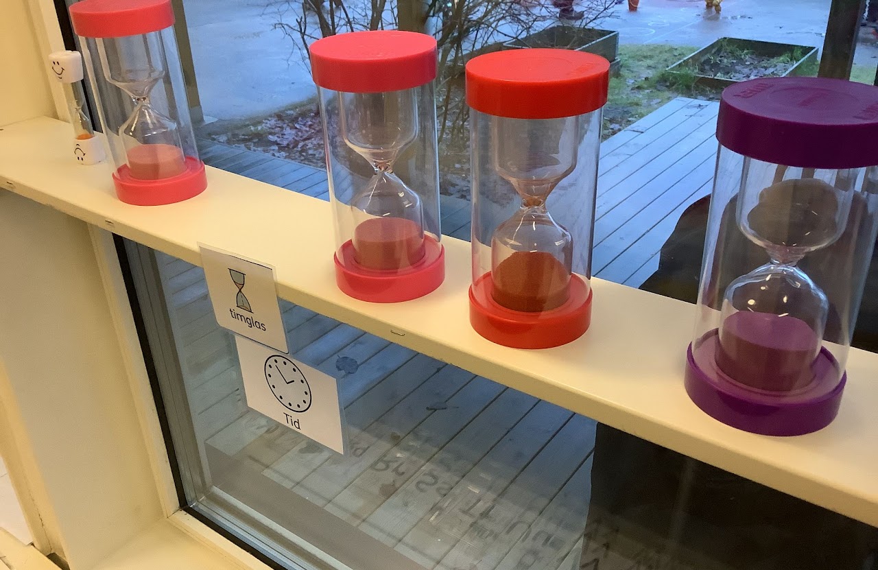 Bilden visar fyra stycken större timglas som står på en fönsterhylla. 