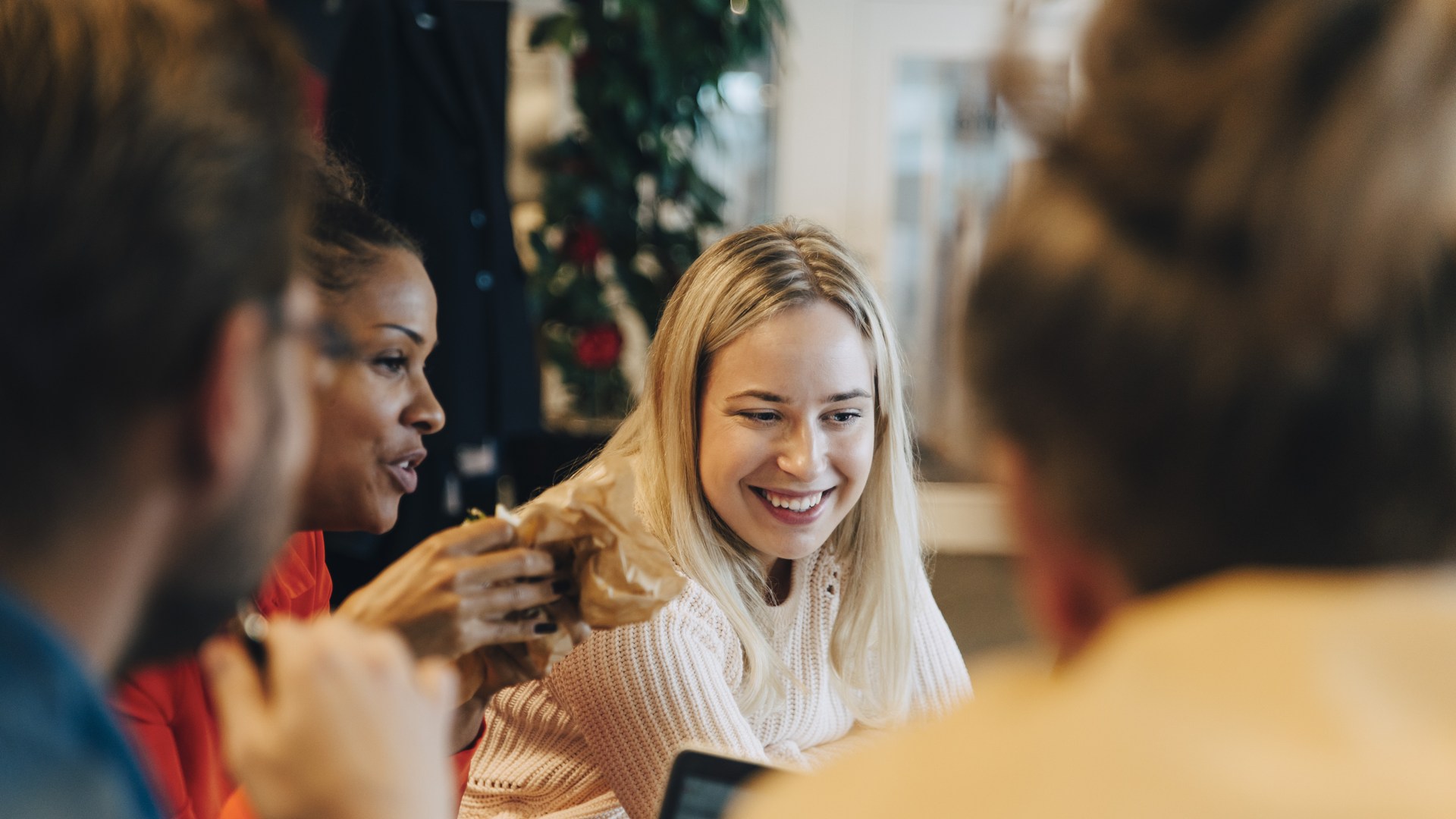 Fyra glada personer som kollar på en dator. 