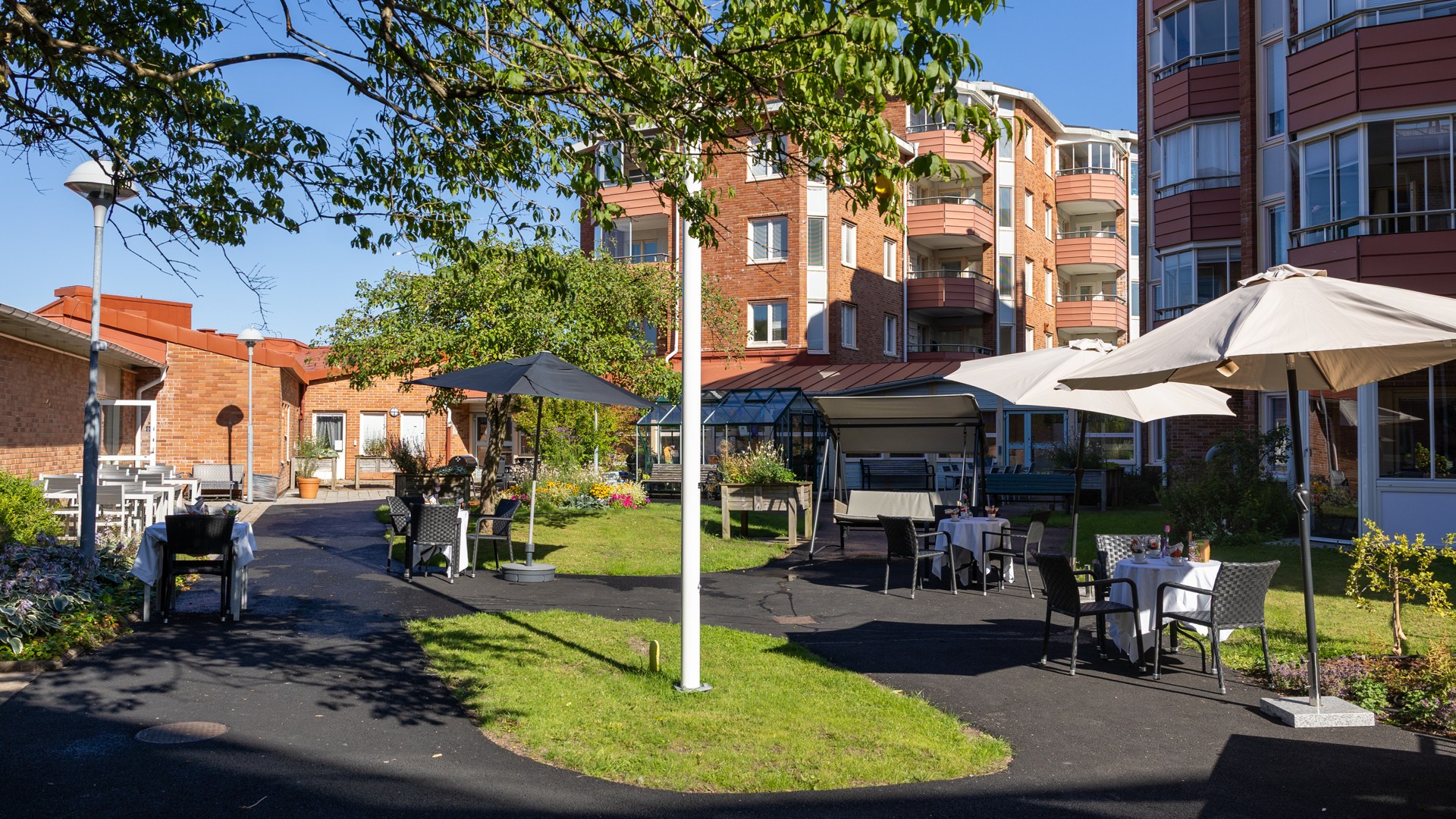 Innergård med sittplatser, bord, grill, växthus med mera.