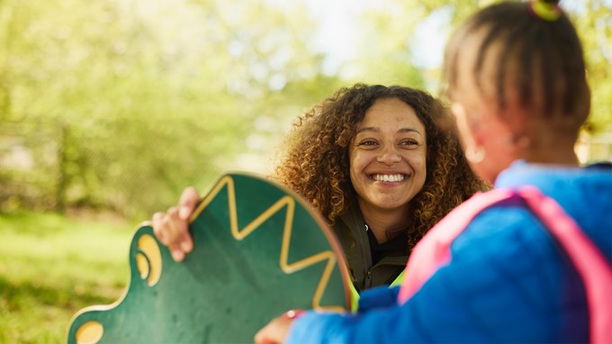 Bild som visar barnskötare som interagerar med ett barn. 