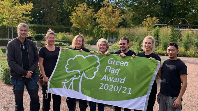 Bild på personal som håller i Green Flag Awards-flaggan.