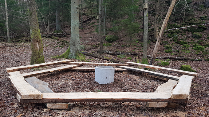 Bild på en grillplats med bänkar runtom, som utgör Björndammen nära skolskog.