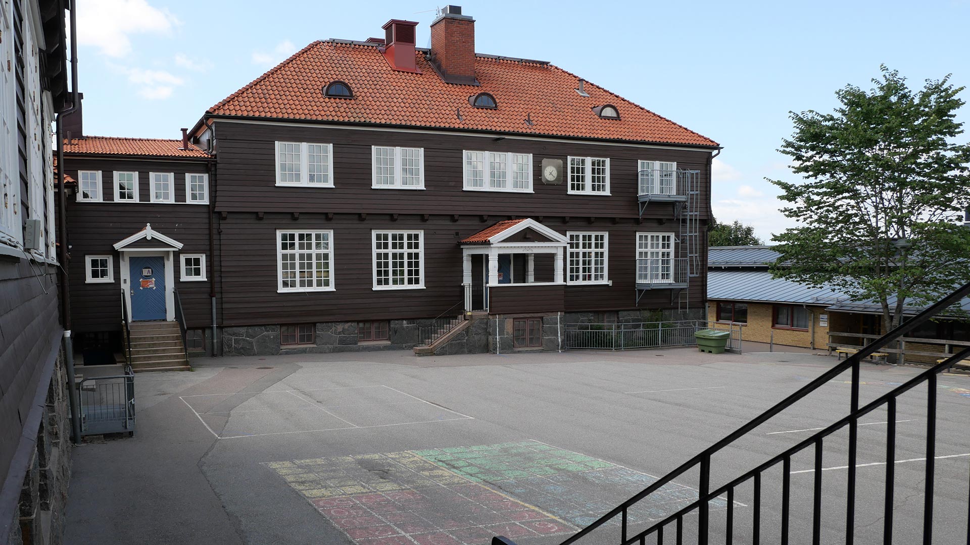 På bilden syns de gamla brunmålade skolbyggnaderna. 