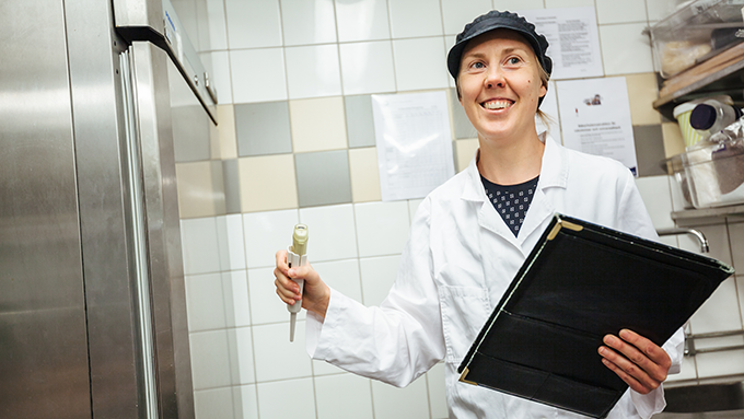 Bild på livsmedelsinspektör som utför kontroll i ett storkök.