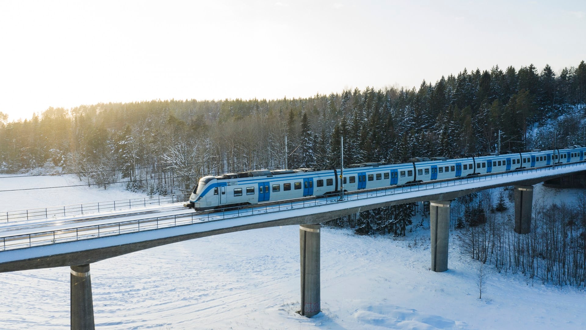 Ett tåg som kör över en bro i snön.