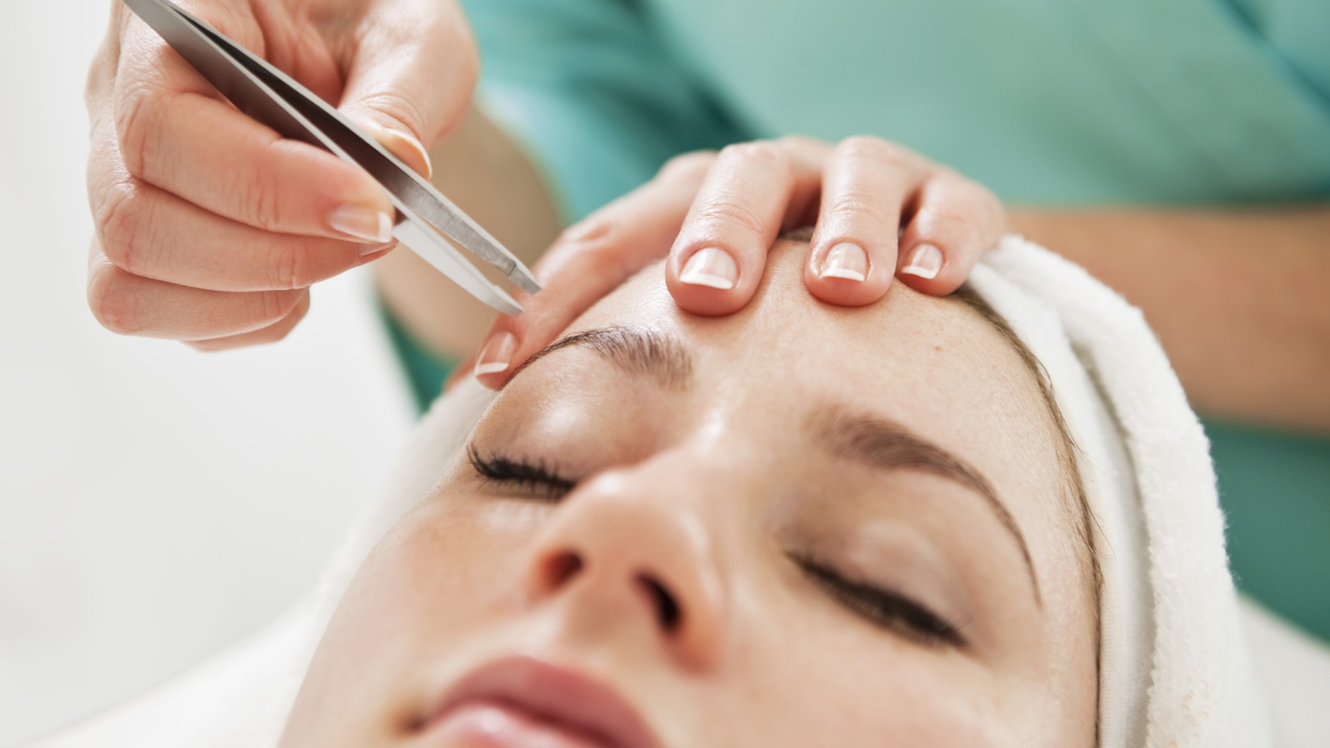 Närbild på kvinna som får sitt ögonbryn fixat.