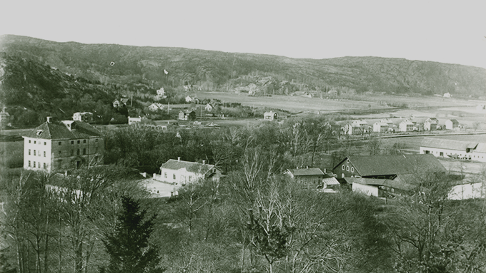 Bild tagen från ovan över centrala Partille, från början av 1900-talet. På bilden syns Partille herrgård, arbetarbostäder, ängar, bergskedjan norr om Lexby samt järnvägen mellan Göteborg och Stockholm. Bilden är svartvit. 