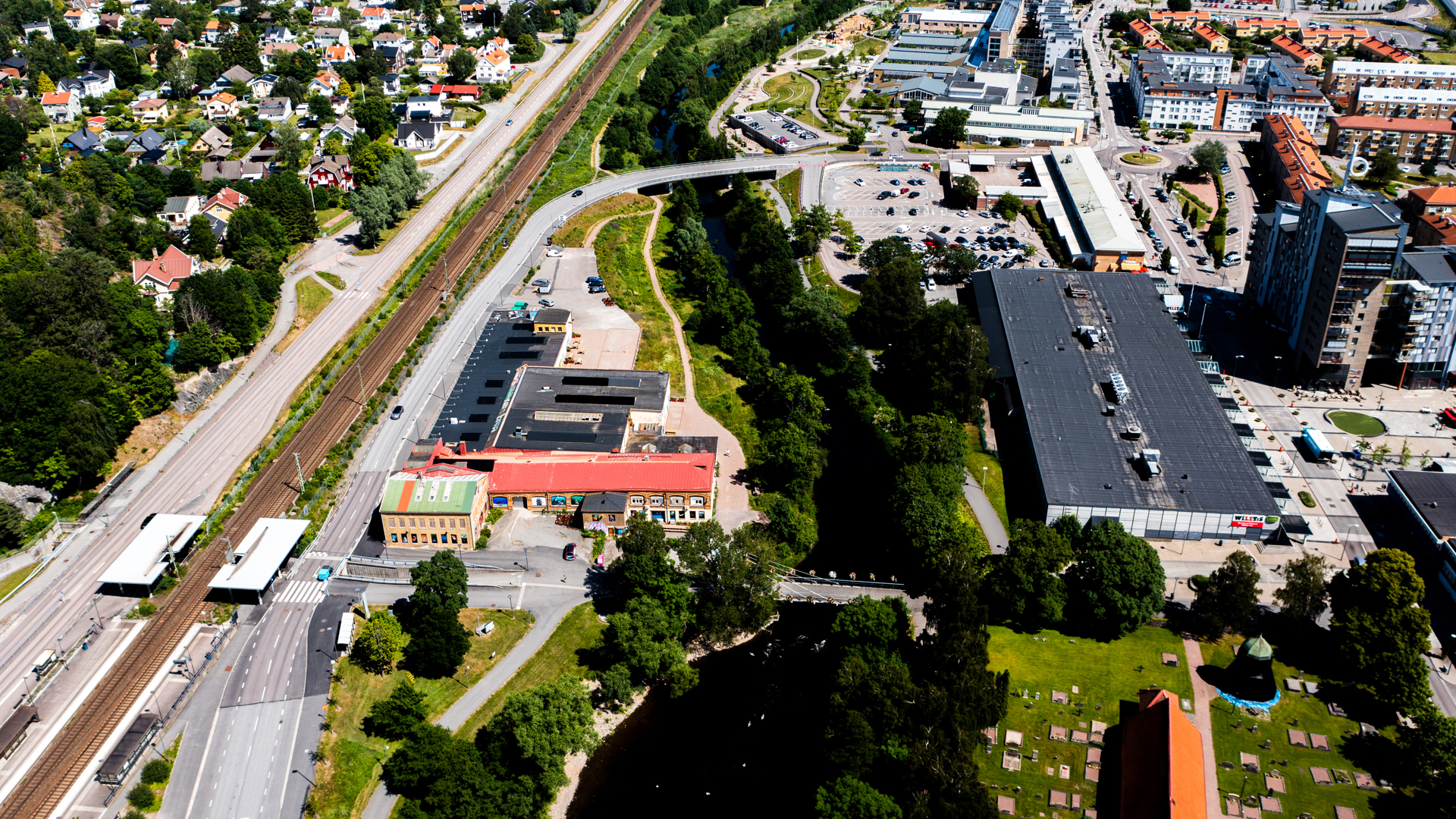 Drönarfoto som visar kvarteret Kniven mellan Partille pendeltågstation och Säveån i Partille centrum.