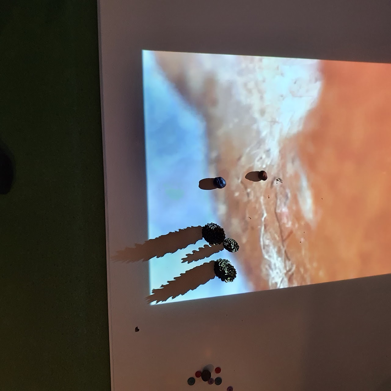 Bilden visar en Whiteboard med en projicerad bild på och på Whiteboarden står några leksaksfigurer. 