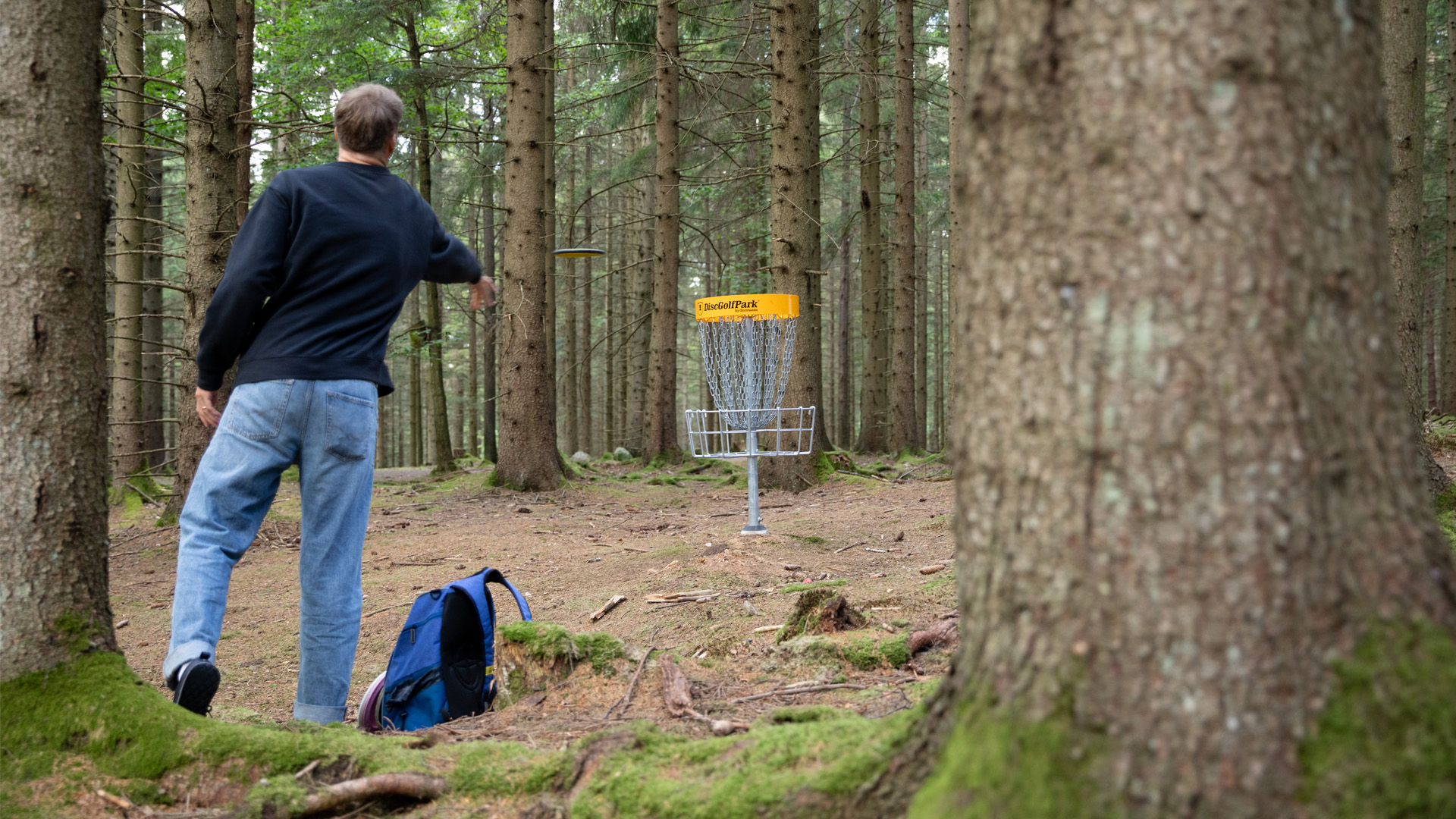 Bild som visar en person som spelar discgolf. 