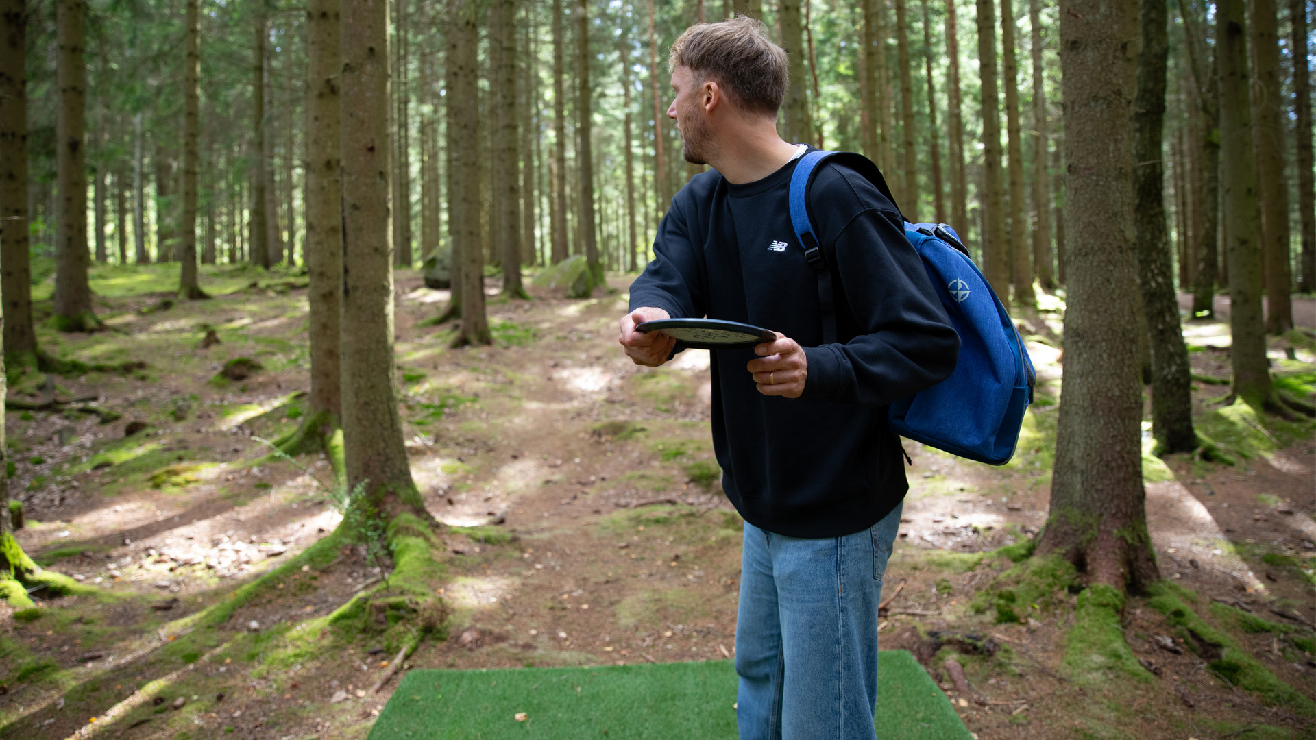 Bild som visar en person som spelar discgolf. 