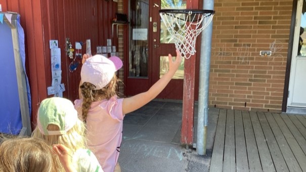 Bild på barn som kastar basketboll. 