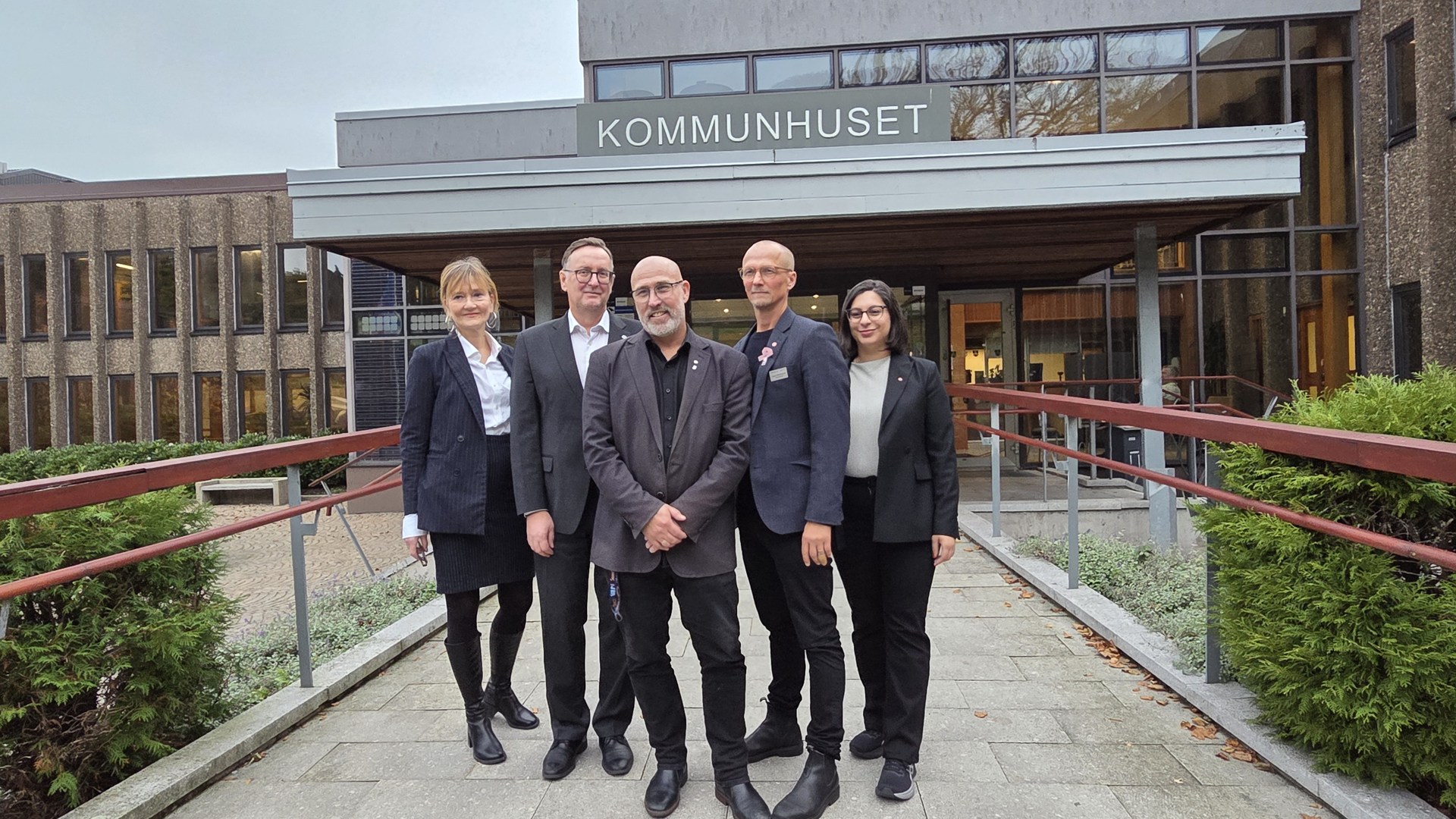 En grupp människor som står framför en byggnad.