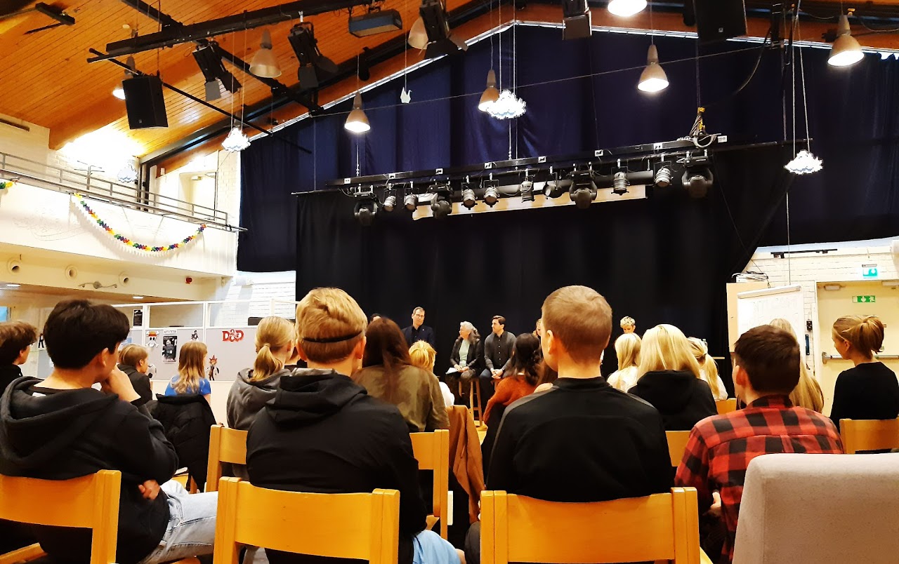 Bild på ungdomar och politiker i en stor sal från en annan vinkel.