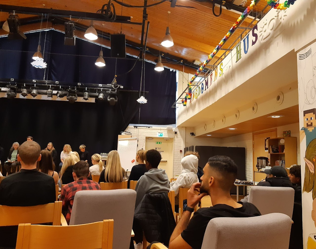 Bild på ungdomar och politiker i en stor sal från en annan vinkel.