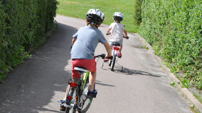Bild på två barn som cyklar på cykelväg.