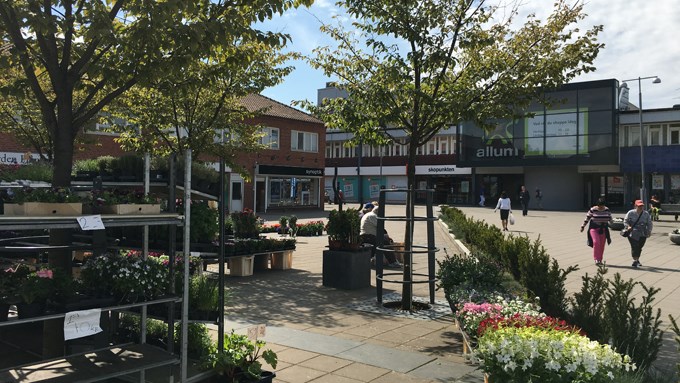 Bild på torg i centrummiljö med blomsterförsäljning.