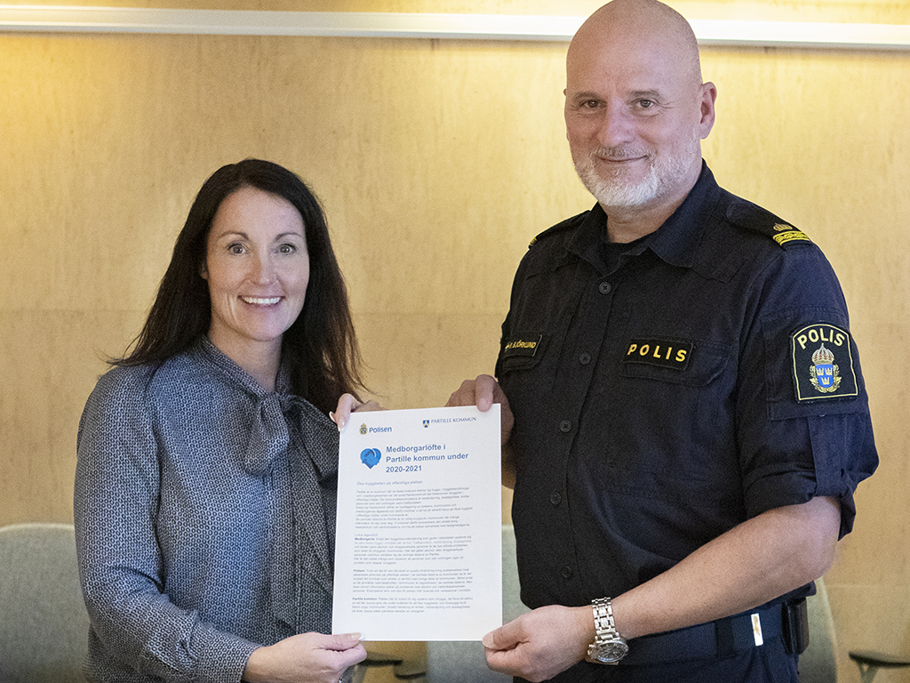 På bilden syns Kommunstyrelsens ordförande Marith Hesse och kommunpolis Robert Björklund. De visar upp det gemensamt förnyade medborgarlöftet för 2020 och 2021, där kommunen och polisen lovar att samverka för att skapa trygghet och säkerhet i den offentliga miljön. 