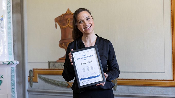 Petra Mede håller i ett diplom som hon har fått för att hon har blivit utsedd till Årets Partilleambassadör i Partille.