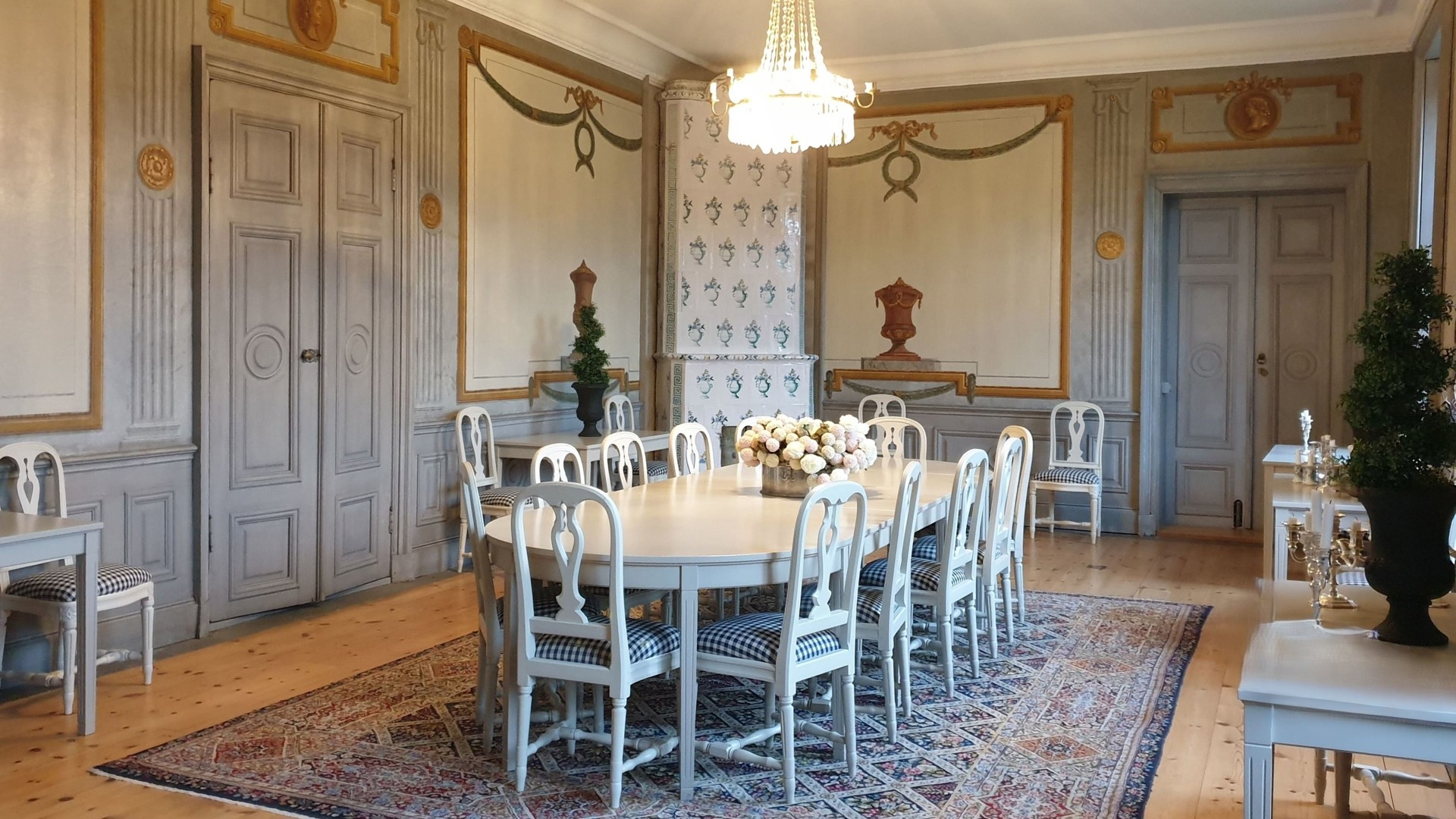 Bild på matsalsrum i Partille Herrgård. Bilden visar dess gamla interiör och där står ett matsalsbord med tillhörande stolar i mitten av rummet.